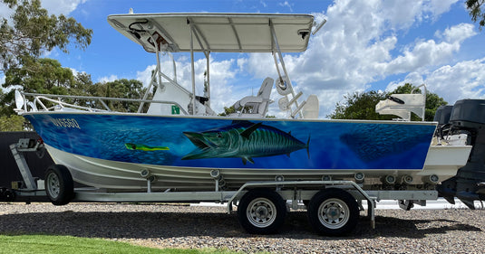 Boat with a Wahoo boat wrap design on the side, parked on a trailer.