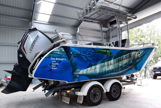 Boat featuring a marlin with a fish design on a trailer inside a building.